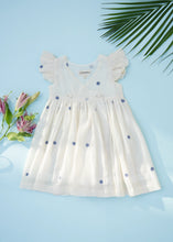 गैलरी व्यूवर में इमेज लोड करें, An image of a handwoven cotton wrap dress with black dotted design, a baby girl's dress on a light bluish background.