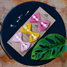 Load image into Gallery viewer, Three hair accessories combo tied on a brown card placed on a black plate with a leaf on the side for decoration.