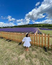 Load image into Gallery viewer, A girl wearing a beautiful white dress posing near a beautiful place.