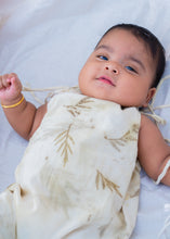 गैलरी व्यूवर में इमेज लोड करें, A kid wearing an cotton jumpsuit eco-printed with silver oak leaves on it sleeping on a bed.