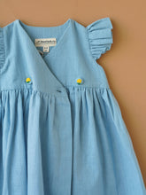 गैलरी व्यूवर में इमेज लोड करें, A designer light indigo flutter sleeve wrap dress kept upon a light peach background.