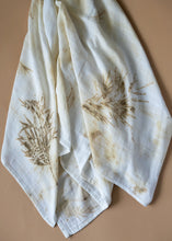 Load image into Gallery viewer, A beautiful muslin baby swaddle with silver oak leaves eco printed on it.