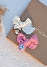 Load image into Gallery viewer, Two (Off-white and Pink) Hair Clips tied to one another on top of a box.