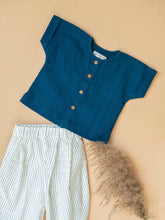 Load image into Gallery viewer, Indigo kurta and balloon pants for boys kept on a peach background with some flower aside.