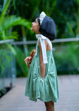 Load image into Gallery viewer, A girl wearing elegant and beautiful secret fairy pocket dress with white headband and holding a toy by posing with her side profile.
