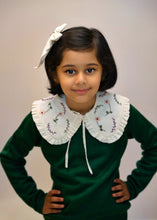 Load image into Gallery viewer, A young kid wearing the white combo of detachable victorian style collar and matching bow with subtle hand embroidery upon dark green top standing in front of a white background.