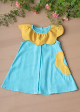 Load image into Gallery viewer, A beautiful dress with petal detailing's around the neck and pockets kept upon a peach background with some flowers aside.