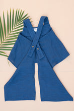 गैलरी व्यूवर में इमेज लोड करें, Backside view of a beautiful Pure Cotton Indigo coloured Pleated Top for kidswear placed on a peach background with a leaf aside