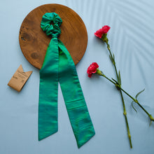 गैलरी व्यूवर में इमेज लोड करें, A beautiful silk hair scrunchie kept upon a round wooden log with some flowers and brown card aside.
