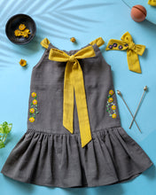 गैलरी व्यूवर में इमेज लोड करें, A beautiful dress with extra-long bow tie strap with a matching hair accessory kept on a blue floor with some leaf, flower and needle aside.