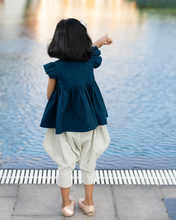 गैलरी व्यूवर में इमेज लोड करें, A young girl pointing towards swimming pool by wearing elegant blue flutter sleeve top and cream balloon pant with blur background.