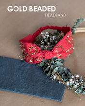 Load image into Gallery viewer, A beautiful gold-beads hand crafted on red cotton fabric hair accessories kept on a dried leaf tiara with some gray sheet under it.