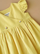 Load image into Gallery viewer, A designer yellow flutter sleeve wrap dress kept upon a light peach background.