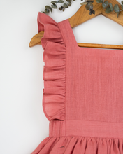 गैलरी व्यूवर में इमेज लोड करें, A beautiful dress with a criss-cross back hung on a hanger with a stem of leaves upon it.