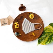 Load image into Gallery viewer, A beautiful, patterned face mask kept upon a round wooden log with some flower, leaf, toys and cards aside.