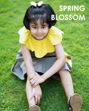 Load image into Gallery viewer, A girl posing wearing a beautiful dress with petal detailing around the neck and pockets.