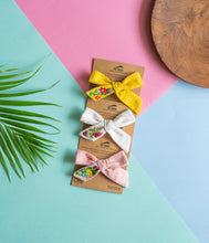 Load image into Gallery viewer, A beautiful combo of hand embroidery hair clips attached to the brown card is kept upon a pastel color background with leave and a round wooden log aside.