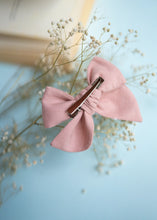 Load image into Gallery viewer, An image of a Daisy delight knot Hairclip with a brown clip for girls,  with an open book on a light blue background-Hair accessories.
