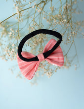 Load image into Gallery viewer, A rear view of the pink and white printed lace bow hair accessory with a band, on a serene sky blue background.
