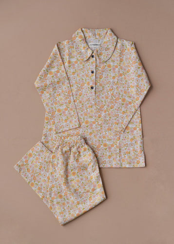 Beautiful cotton pajamas set kept upon a peach background.