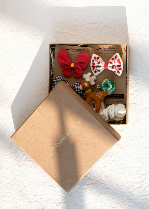 Beautiful brown box containing some Christmas hair accessories with some toys, placed on a white background