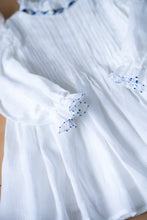 Load image into Gallery viewer, A closeup look of pintuck detailing across the bust and ruffles running across the neckline in classic white palette.
