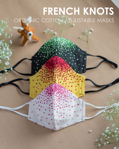 A colourful French knots organic cotton adjustable masks with some toy and flower aside.