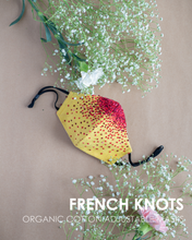 Load image into Gallery viewer, A colourful French knots organic cotton adjustable masks with some toy and flower aside.
