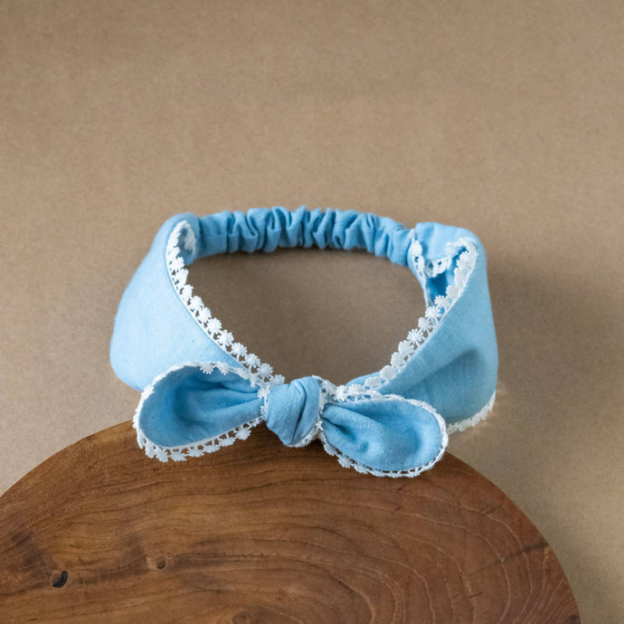 A beautiful blue lace headband kept upon a wood.