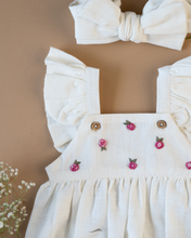 Load image into Gallery viewer, A cute romper with some flower embroidery on it with matching hair accessory and flower aside.
