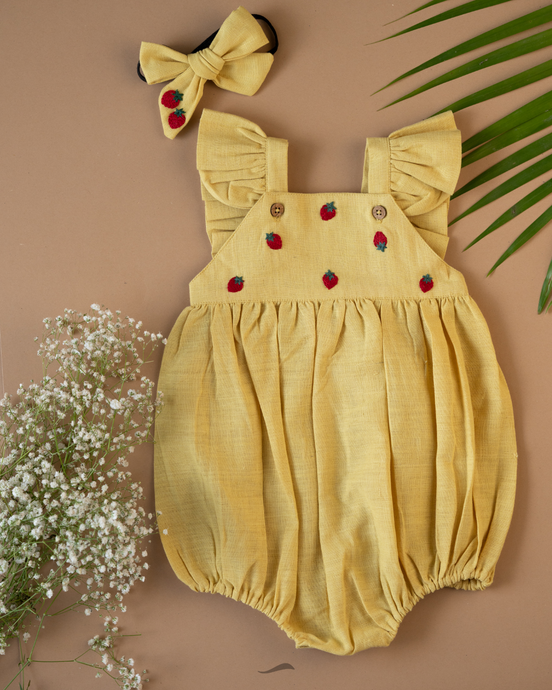 A cute romper with some strawberry embroidery on it with matching hair accessory, some leaf and flower aside.