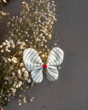 Load image into Gallery viewer, A cute butterfly hair accessory kept upon a flower.
