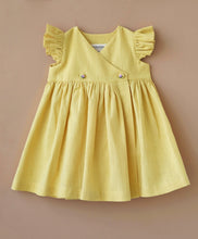 गैलरी व्यूवर में इमेज लोड करें, A designer yellow flutter sleeve wrap dress kept upon a light peach background.
