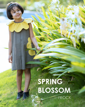 Load image into Gallery viewer, A girl posing by wearing a beautiful dress with petal detailing around the neck and pockets beside a bunch of plants.
